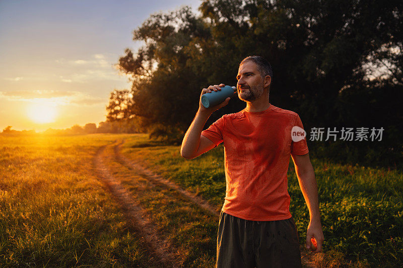 一名男子在慢跑后用他的水瓶喝水