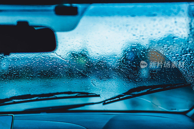 雨点落在挡风玻璃上。下雨了。恶劣的天气