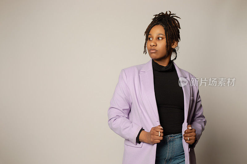 非裔美国女性，她穿着淡紫色的运动上衣，身体前倾，目光移开