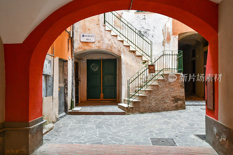 意大利里维埃拉的Ponente老渔村的一个庭院的拱门，有一个石头楼梯和彩色的墙壁，Laigueglia，萨沃纳，利古里亚，意大利