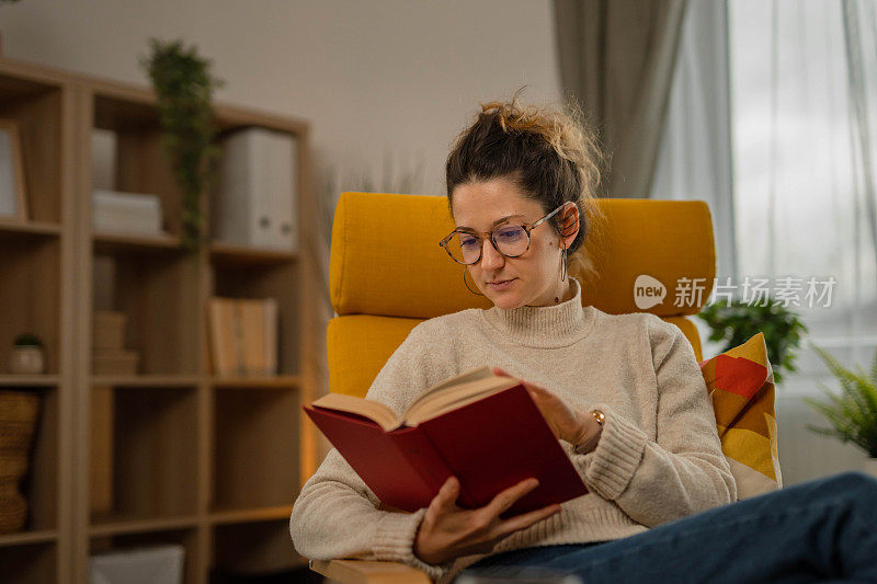 一个成年妇女在家里的客厅里看书