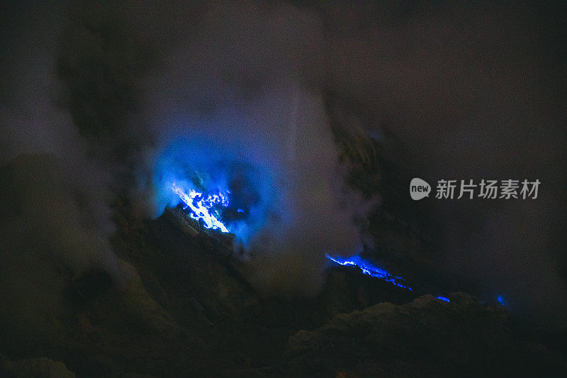 印度尼西亚东爪哇，伊真火山的壮观日出，蓝色的火焰和明亮的黄色硫磺蒸汽在绿松石湖之上