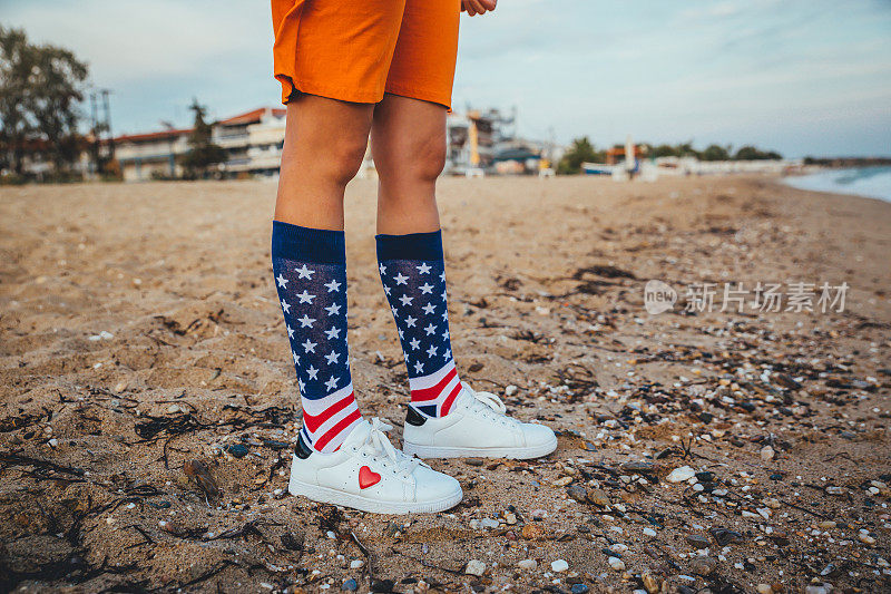 一个女人在海滩上穿着印有美国国旗的袜子