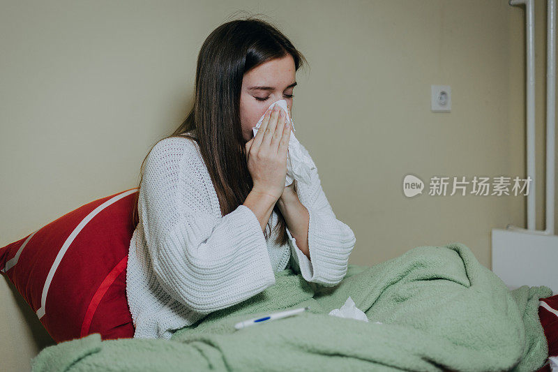 女病人躺在床上，盖着毯子