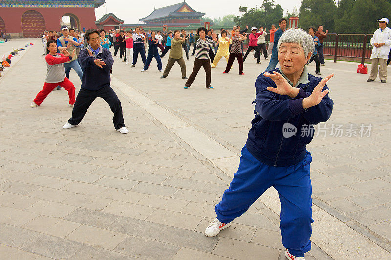 中国北京，一群老年人在户外练习太极拳。