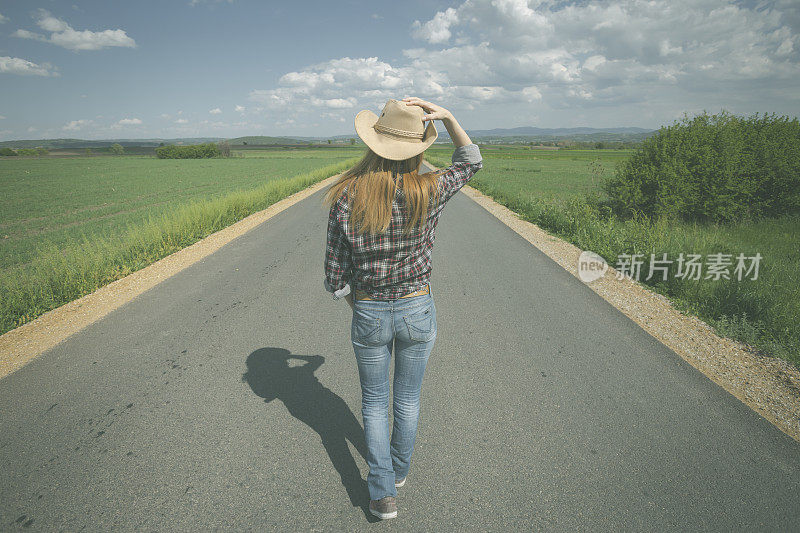 牛郎姑娘走在笔直的马路中间穿过碧绿的草地