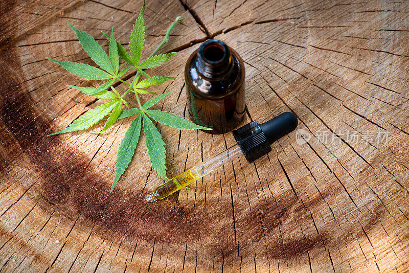 大麻药油装在一个天然木头上的小瓶子里