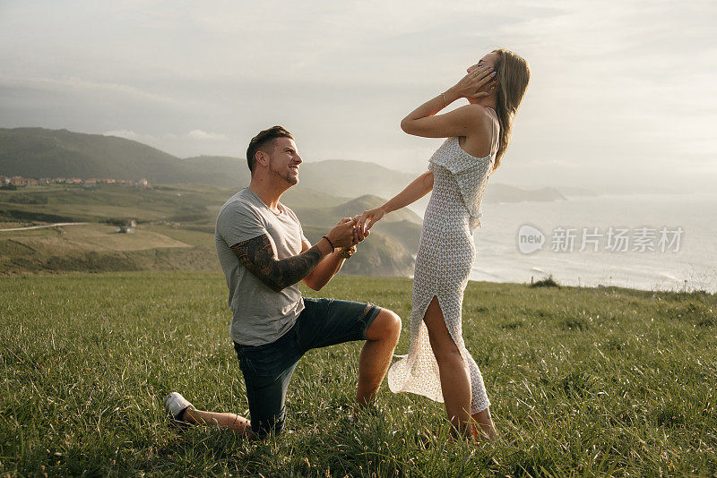 一个年轻人在海边向他的女朋友求婚