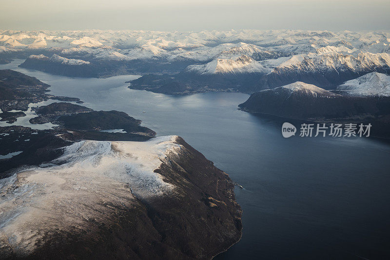 乘客从飞机上俯瞰挪威的峡湾，山上覆盖着积雪