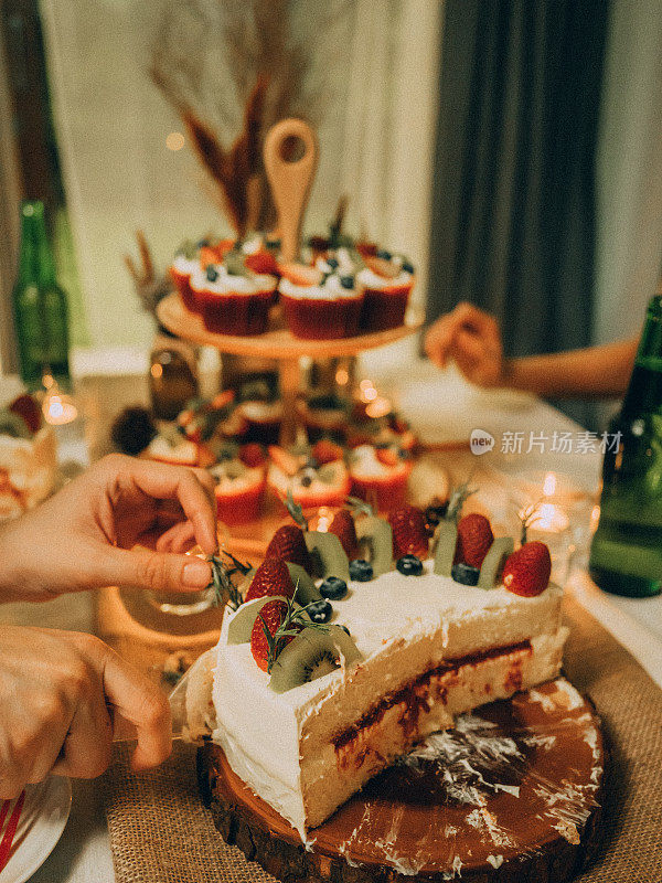 祝亚洲朋友在家吃蛋糕庆祝生日快乐。