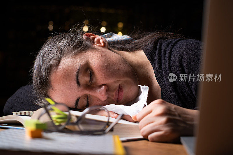 疲惫的年轻女子在桌上睡着了