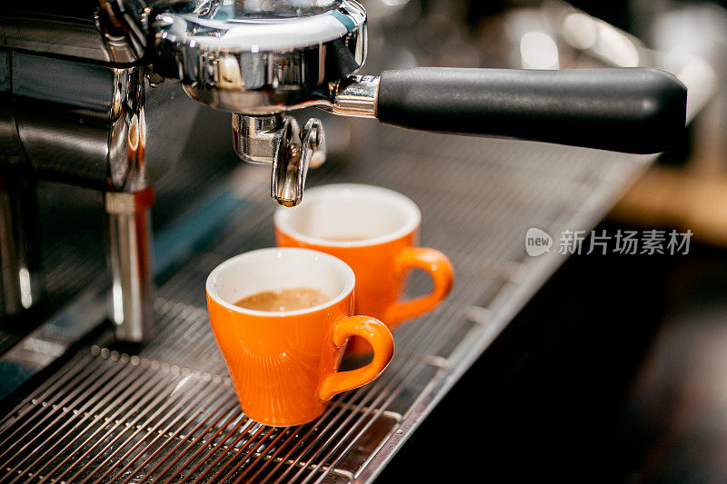 咖啡师用咖啡机制作两个浓缩咖啡杯