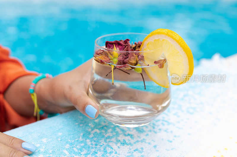 在泳池边喝着水，在户外玩。夏季和生活方式的概念