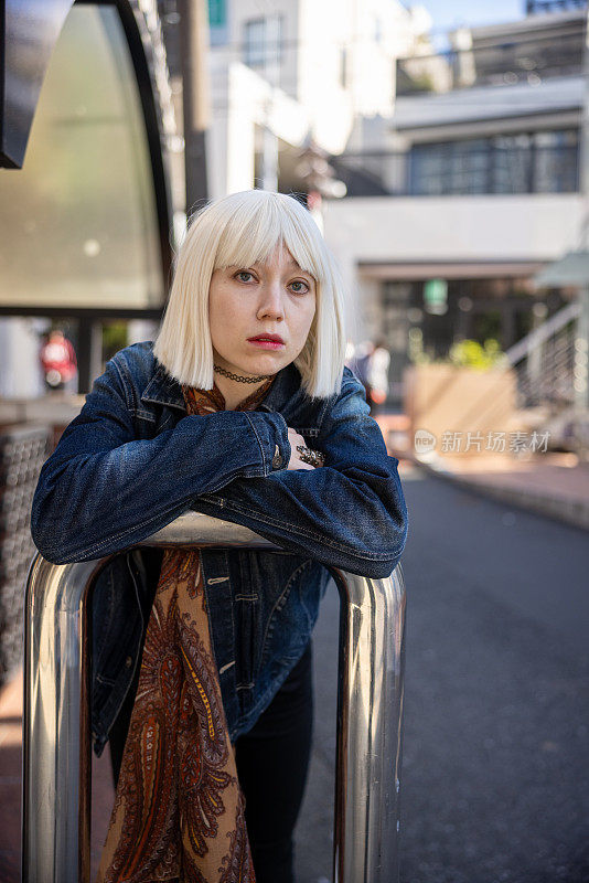 年轻女子的肖像与白金色假发放松在街上