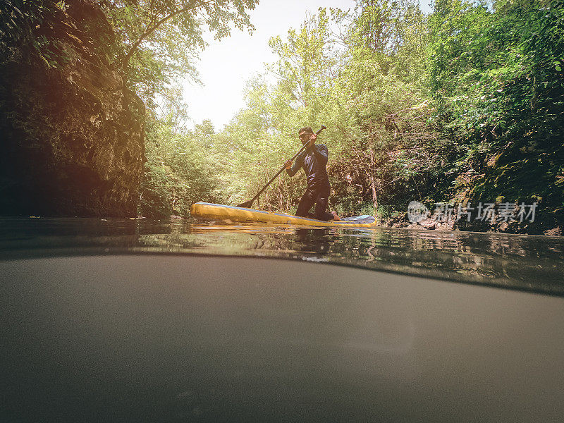 男人paddleboarding