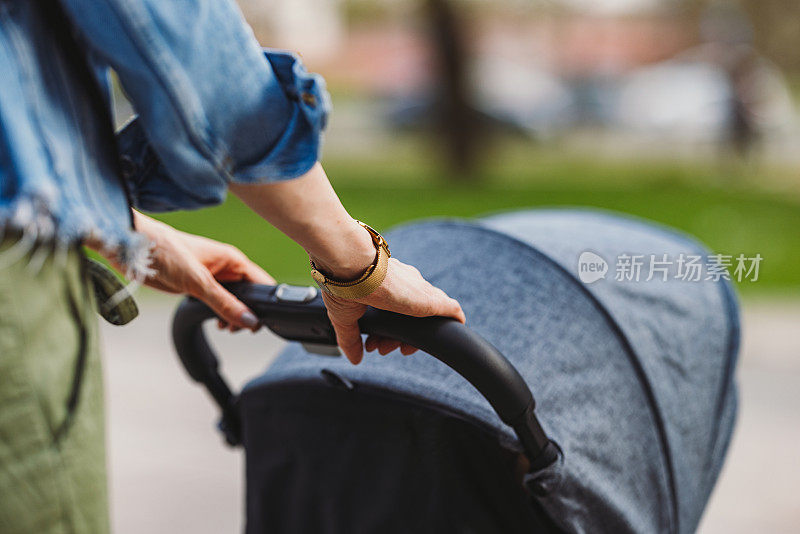 匿名女子推着婴儿车在公园里