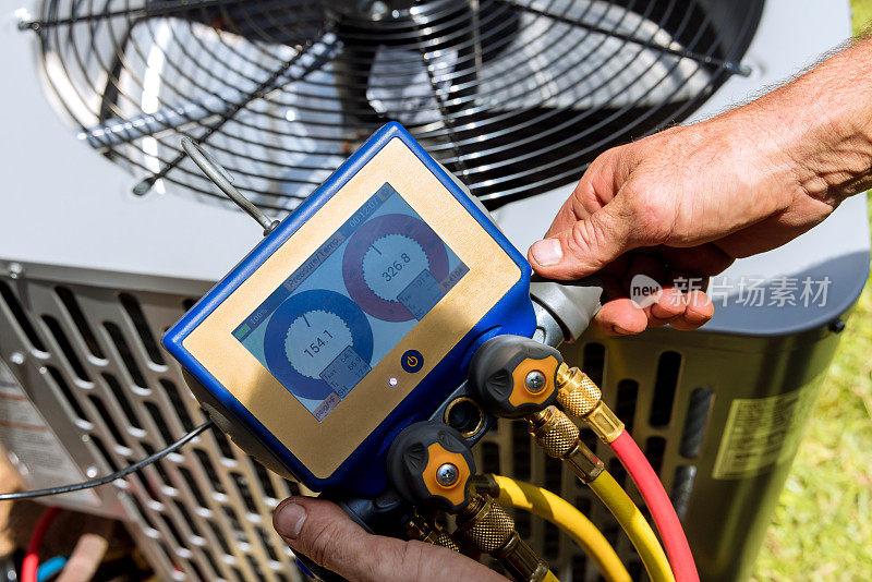 空气修理技师使用测量设备安装空调