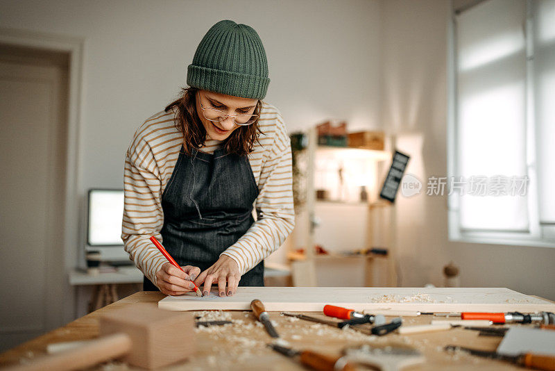 女艺术家在艺术工作室工作台上的木头上作画