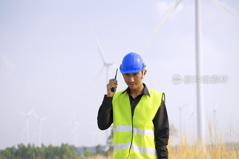 电力工地的蓝领工人。风车。