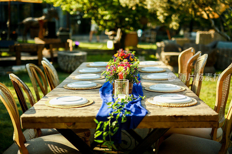 乡村婚礼风格，木制餐桌，花卉装饰，餐具