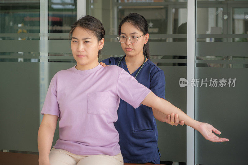 与女医生或物理治疗师进行脊椎按摩手臂和肩膀调整的亚洲女性患者的医疗访问