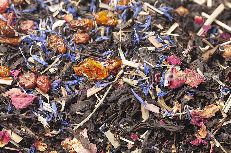 红茶配柠檬草，醋栗，沙棘，玫瑰花瓣，矢车菊花瓣背景俯视图