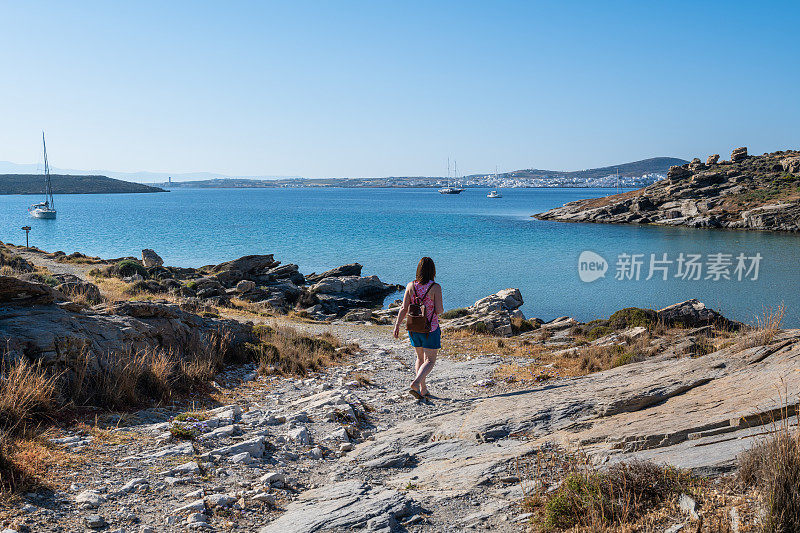 女旅行者探索平静的海湾边缘