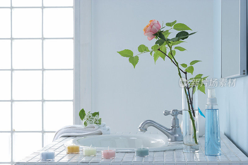 浴室里的水槽，花瓶里的玫瑰和肥皂