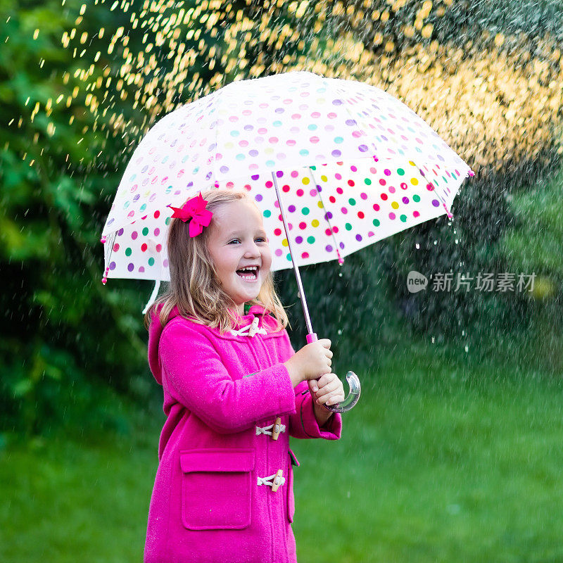 小女孩撑着伞在夏日的雨中