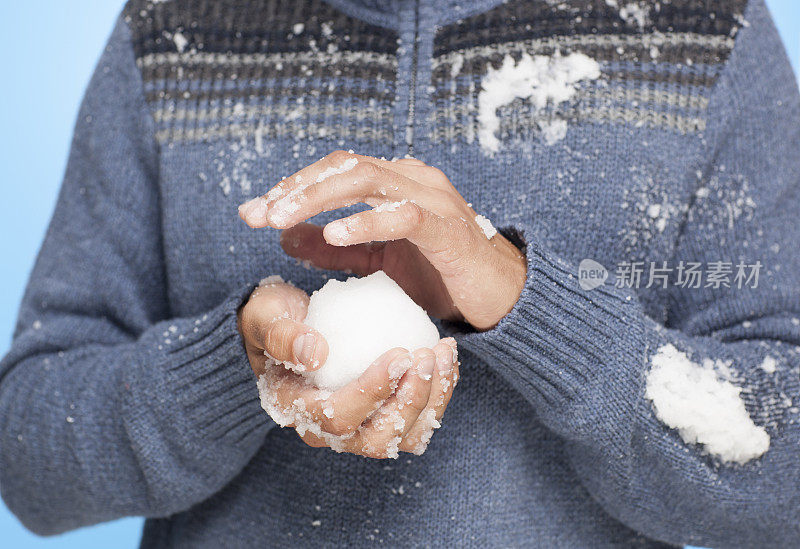 不认识的人拿着雪球。