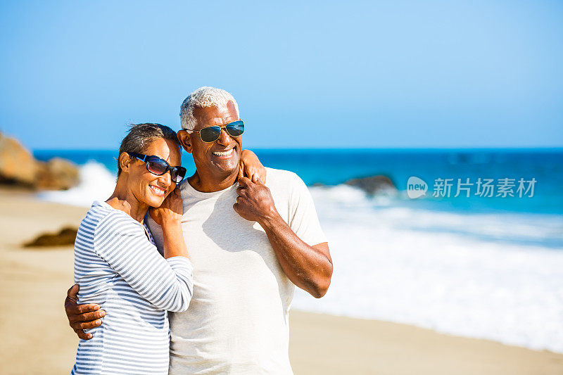 一对非洲裔美国老年夫妇在海滩上拥抱