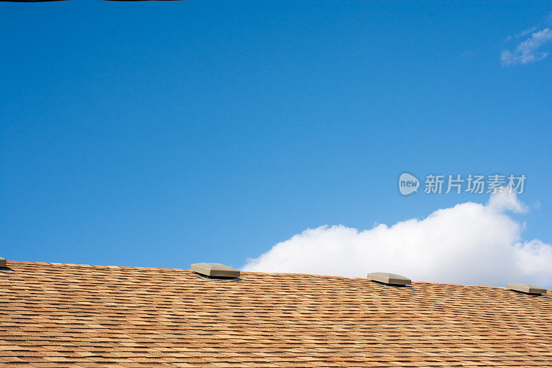 金属屋顶通风口的新瓦屋顶和天空