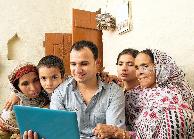 愉快的印度家庭使用笔记本电脑