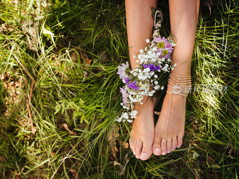 少女镶着宝石的脚在绿草如茵的草地上