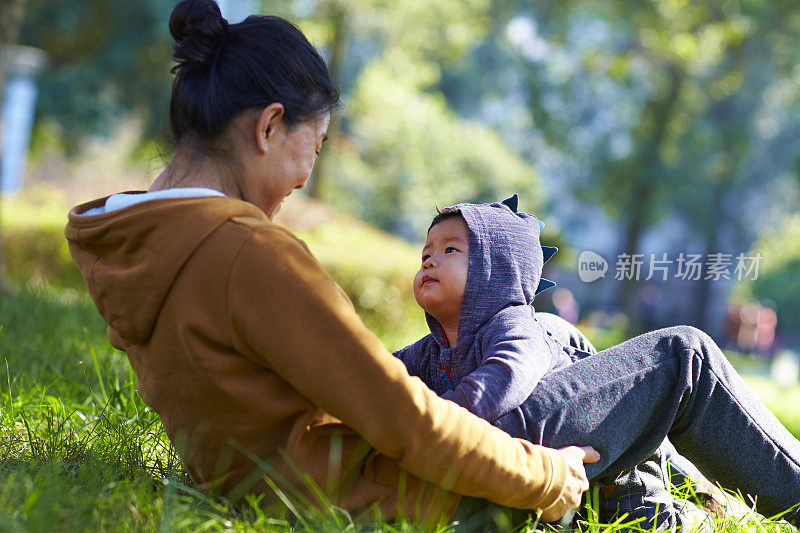 可爱的小男孩和他的奶奶在公园外面