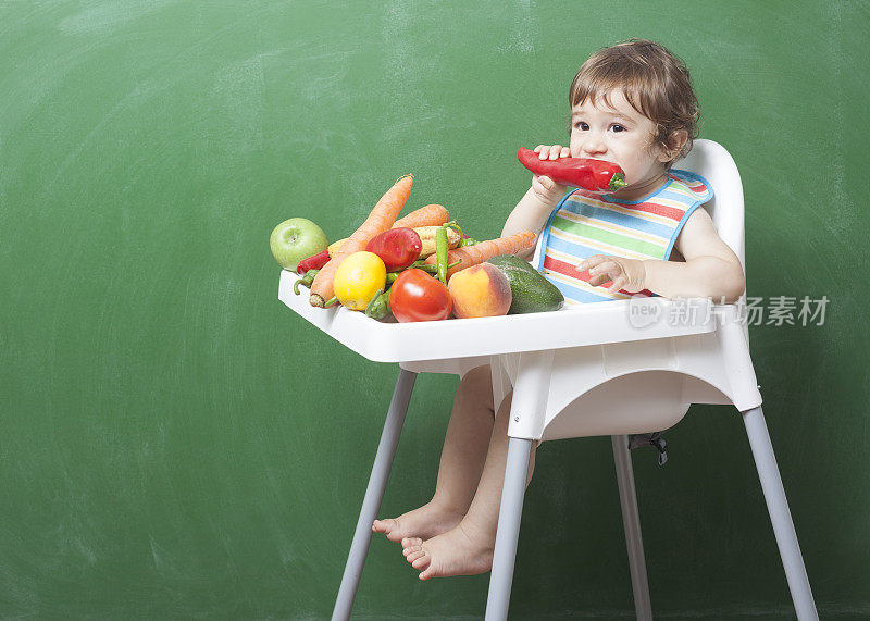小男孩在黑板前吃水果