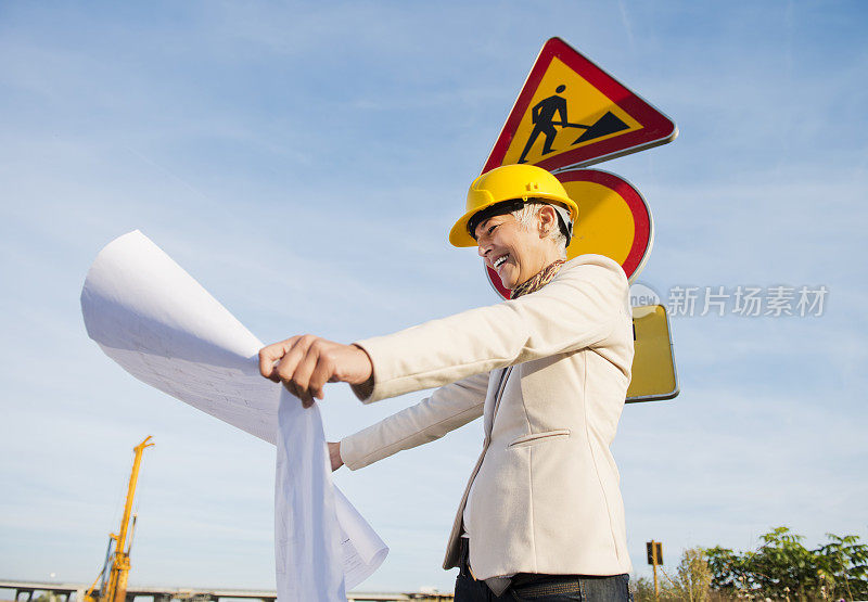 成熟的女人像建筑师一样站在路标前