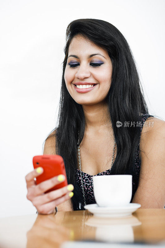 漂亮的年轻褐发女人微笑手机短信