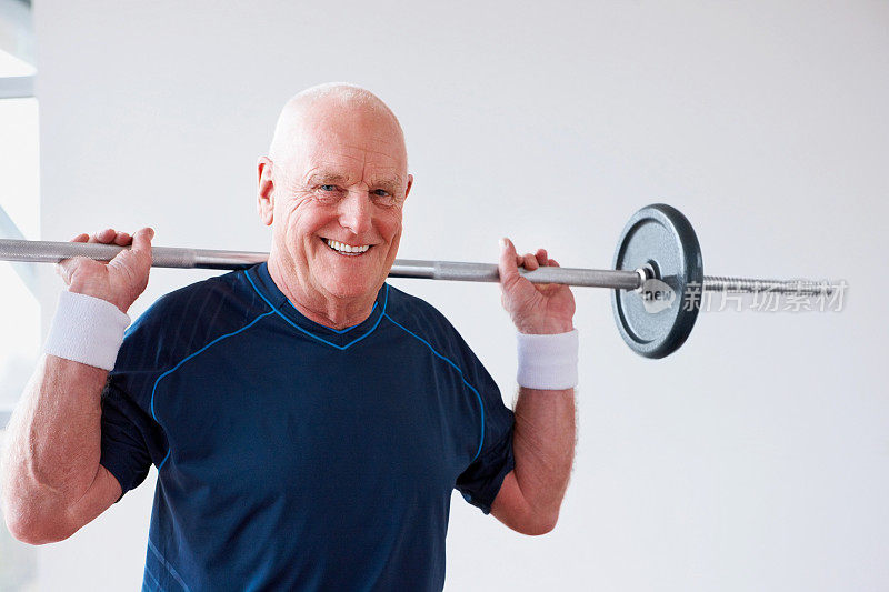 健康的老年人在健身房举重