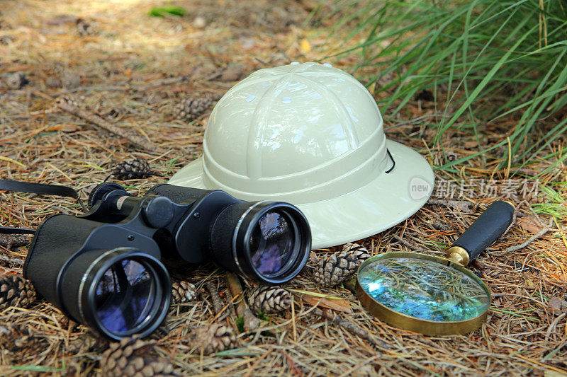 森林中的双筒望远镜，放大镜和木髓头盔