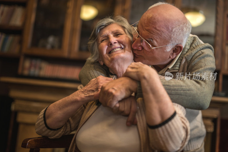 爱老男人在家里亲吻拥抱他的妻子。