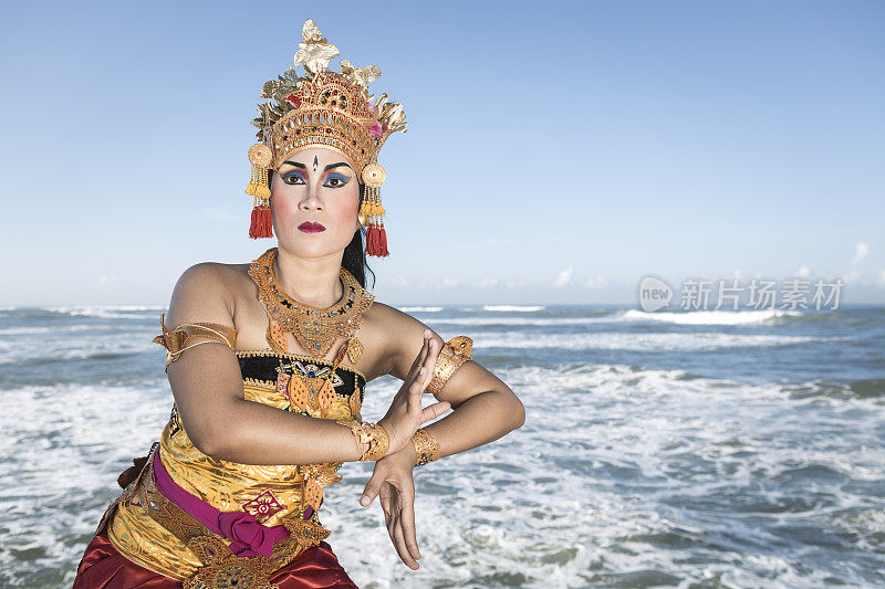 巴厘岛的女舞者穿着传统服装在蓝色的海洋