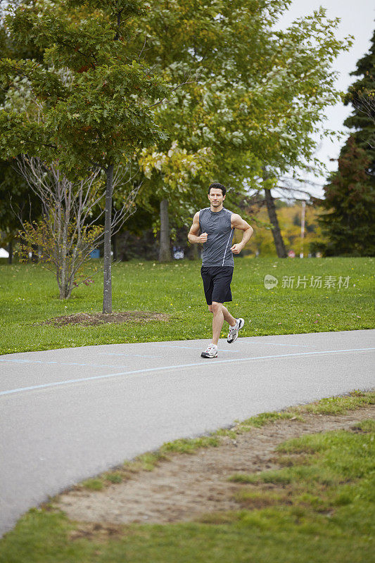 运动男子灰色健身运动服在公园里跑步