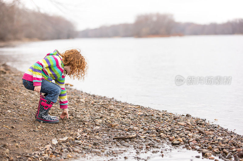 河岸上捡石头的女孩