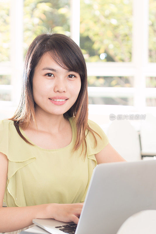 亚洲女孩在教室里用笔记本学习