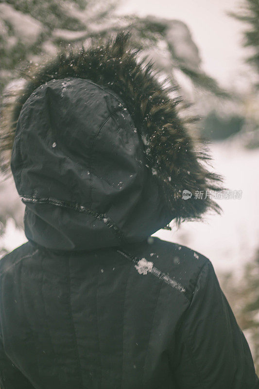 冬天的女人在寒冷的冬日里，在雪地里仰望着快乐的微笑。