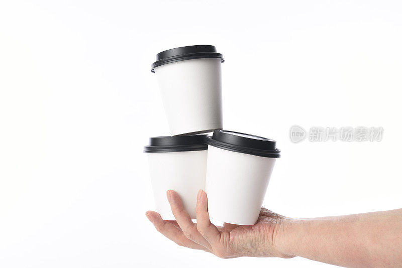 拿着三个空白的一次性纸咖啡杯，背景是白色