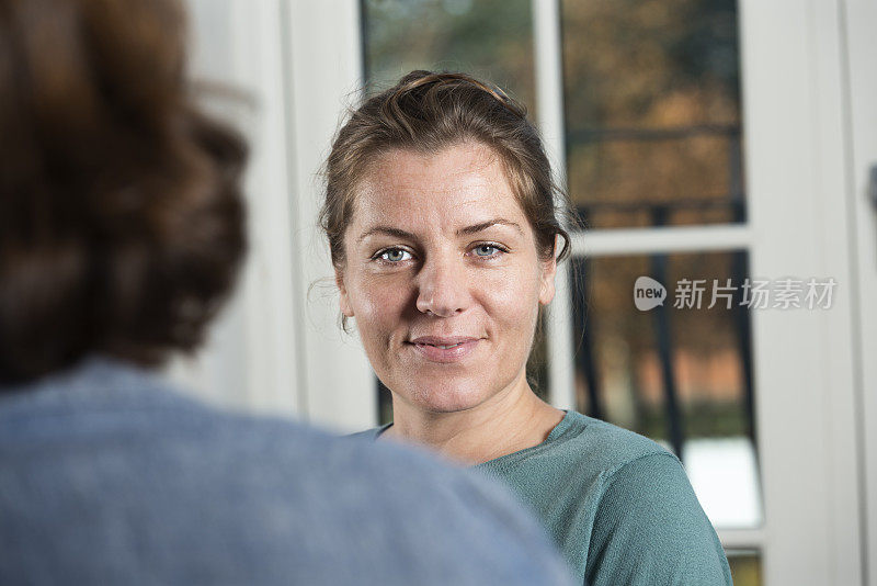 快乐的年轻女子与同事交谈。