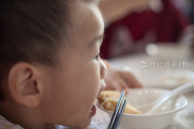 亚洲男孩吃碗里的食物