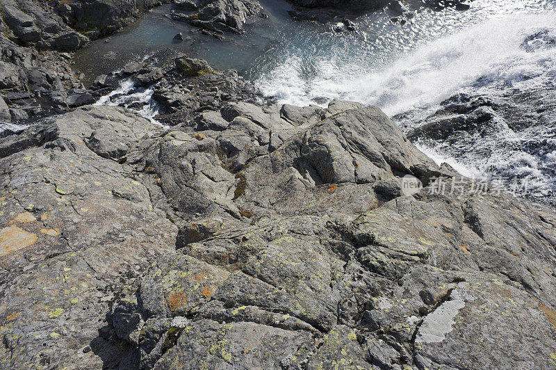 沿瀑布从高耸的挪威山脉的山顶俯瞰下山